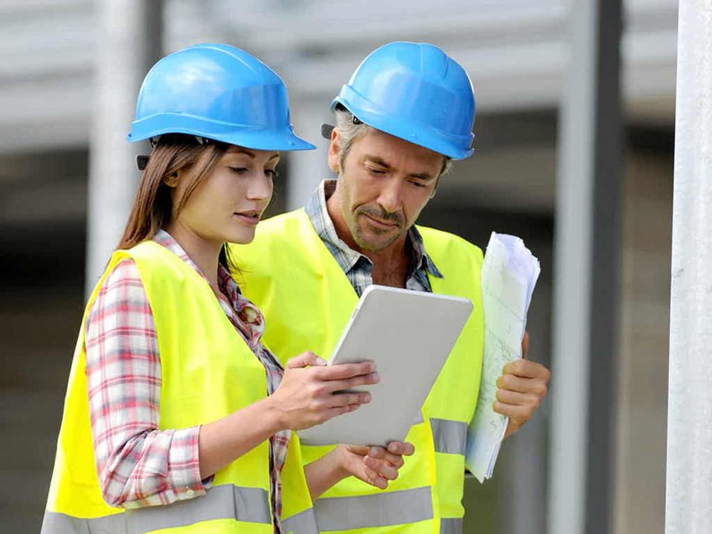 Benefits of Changing from Paper to Digital Forms with Mini Case Studies - man and woman standing with digital forms in construction site
